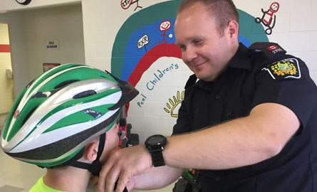 Male employee putting bike helmet onto child