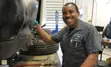 Male fleet employee smiling to camera while working on a car