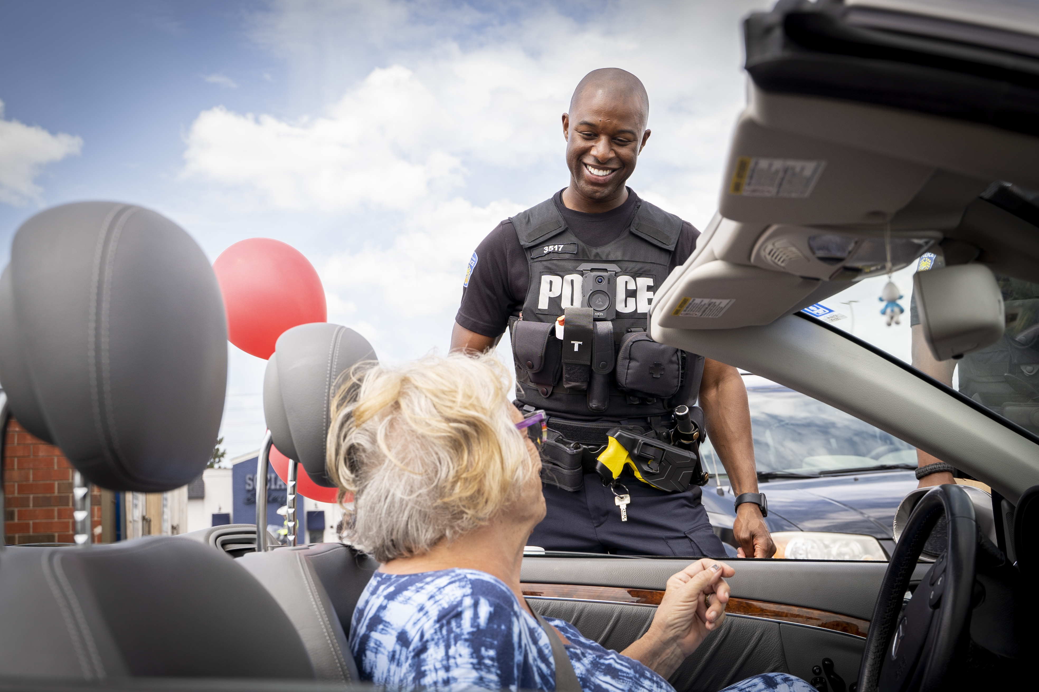 Police officer smiling helping senior citizen
