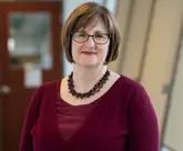 smiling female standing in office hallway