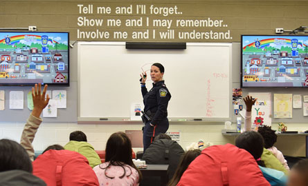Group of kids sitting on bean bag chairs with teacher