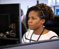 female communicator wearing headset looking at computer