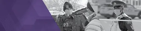officer wearing toque while snow falling and traffic officer wearing mask and neon vest