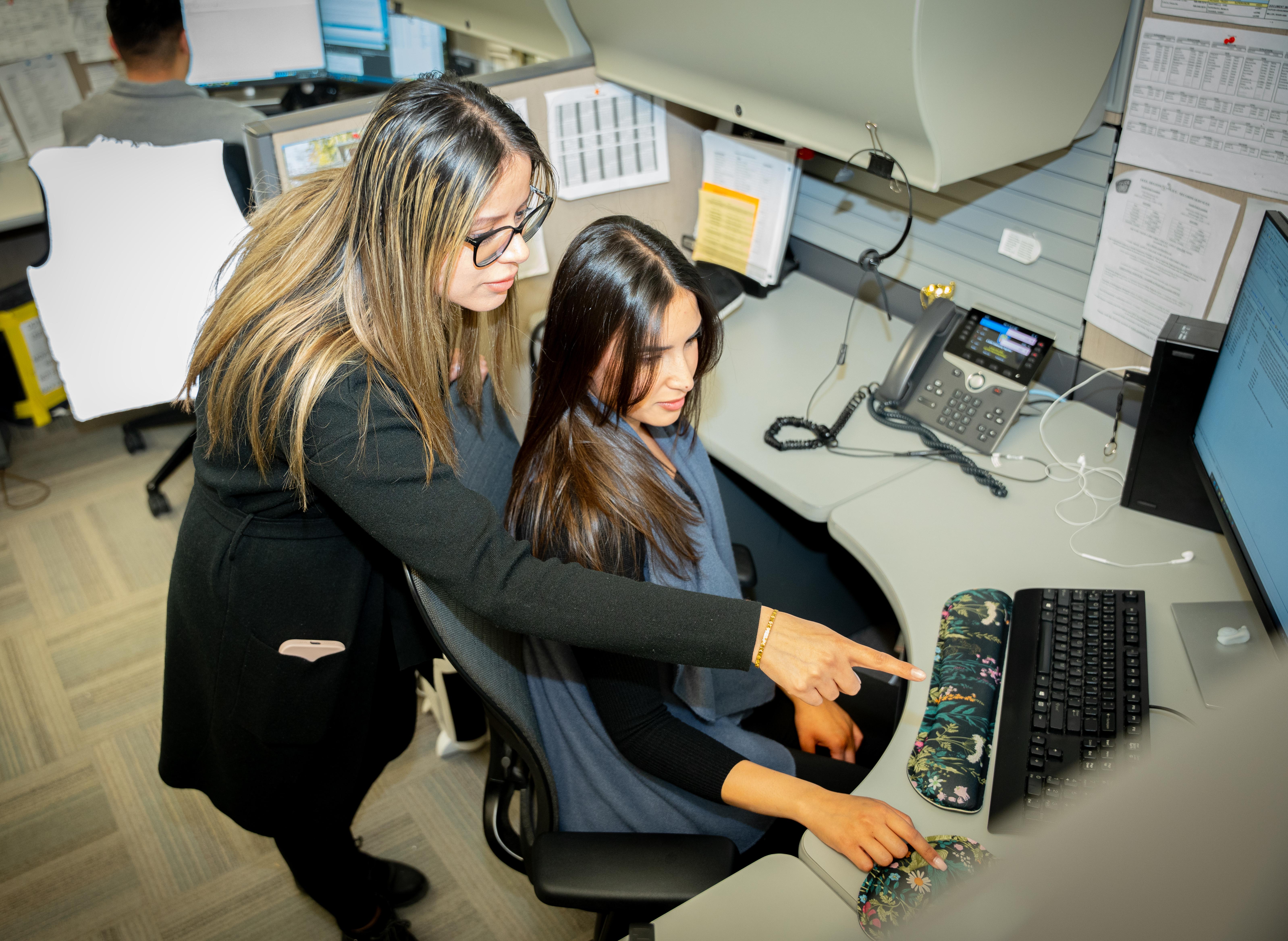 Female office workers point to computer