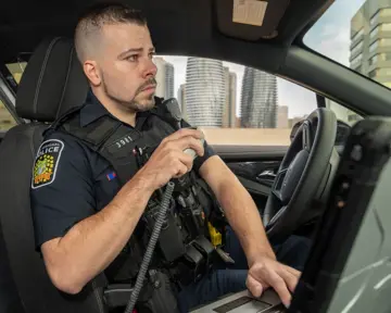 Police officer making radio call in cruiser