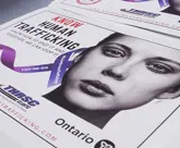 human trafficking poster with lady's face and purple ribbon