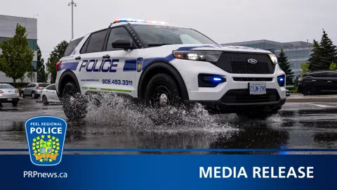 Peel police cruiser splashing through puddle